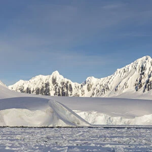 Snow-covered mountains and dense sea ice in Neumayer Channel, Palmer Archipelago