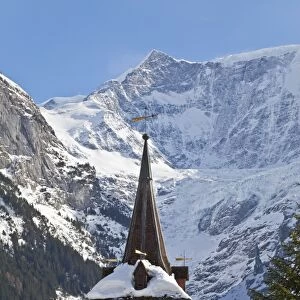 Snow and ice covered mountains above the village church in Grindelwald