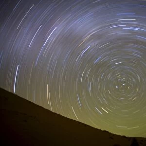 Star trails captured using an exposure time of two hours to record the rotation of the earth on its Polar Axis, stars are rotating around the Pole Star (Polaris), the Sahara Desert near Merzouga, Morocco, North