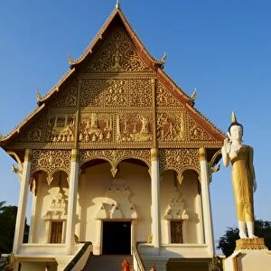 Statue of standing Buddha and monks, Pha That Luang temple, Vientiane, Laos