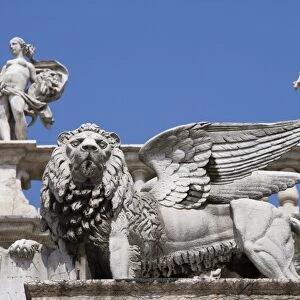 Statue of winged Venetian lion in front of statues of Venus and Mercury on the top of the Palazzo Maffei, Verona, Veneto