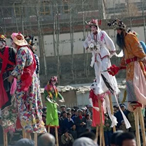 Stilt dancers in parade at New Year celebrations in Qinghai Province, China, Asia