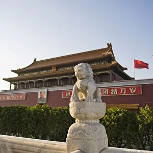 Stone lion statue at the main entrance to The Forbidden City, Chairman Mao Tsedongs portrait hanging above the doorway, Beijing