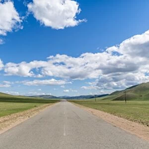 Straight road in the Mongolian steppe and clouds in the sky, North Hangay province