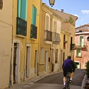 Street with cyclist, Old town, Bouzigues, Thau basin, Herault, Languedoc, France, Europe