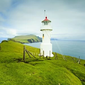 Stunning coastal scenery and the Mykinesholmur lighthouse, a footbridge connects this islet with the island of Mykines over a 35 metre deep gorge, Mykines Island, Faroe Islands