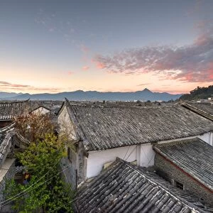 The sun is about to rise over the roofs and mountains of Lijiang Old Town, UNESCO World Heritage Site, Lijiang, Yunnan, China, Asia