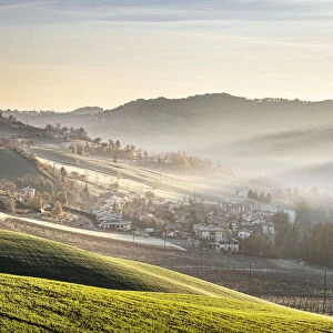 Sunrise light in the mist on gentle hills in the countryside, Emilia Romagna, Italy