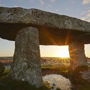 A sunrise view of the remains of a prehistoric burial chamber, known as Lanyon Quoit
