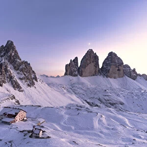 Sunset over Monte Paterno, Tre Cime di Lavaredo and Locatelli hut covered with snow
