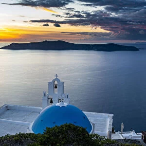 Sunset over the volcanic islands of Santorini and Anastasi Orthodox Church at sunset
