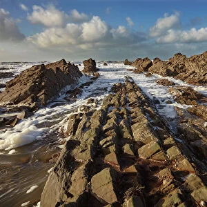 Surf rolling onto a rocky Atlantic shore, at Widemouth Bay, near Bude, Cornwall