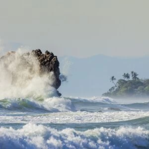 Surf on a sea stack between Santa Teresa and Hermosa beaches, far south Nicoya Peninsula