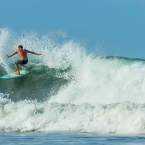 Surfer on shortboard riding wave at popular Playa Guiones surf beach, Nosara, Nicoya Peninsula, Guanacaste Province, Costa Rica, Central America