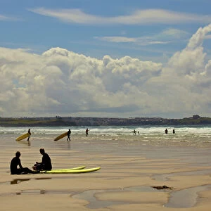 Surfers with boards on Perranporth beach, Cornwall, England