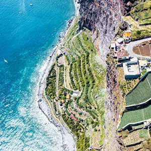 Terraced green fields by the turquoise ocean from above, Camara de Lobos, Madeira island