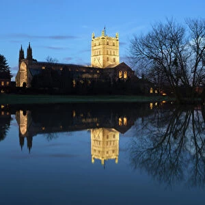 Tewkesbury Abbey reflected in water at dusk, Tewkesbury, Gloucestershire, England