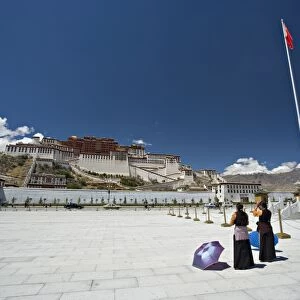 Two Tibetan women praying, in front of the Potala Palace, UNESCO World Heritage Site