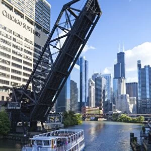 Tour boat passing under a raised disused railway bridge on the Chicago River, Downtown towers in the background, Chicago, Illinois, United States of America, North America