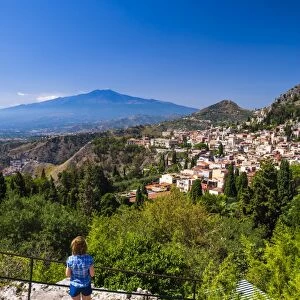 Tourist admiring the view of Mount Etna from Teatro Greco (Greek Theatre), Taormina, Sicily, Italy, Europe