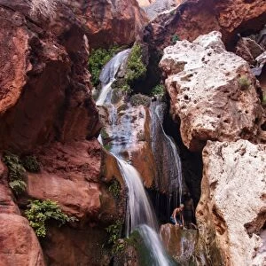 Tourist bathing in a waterfall, seen while rafting down the Colorado River, Grand Canyon, Arizona, United States of America, North America