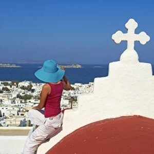 Tourist on roof of red church above the old town, Mykonos town, Chora, Mykonos