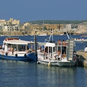 Tourists boarding boats from a jetty in St