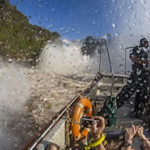 Tourists take a river boat to the base of the falls, Iguazu Falls National Park