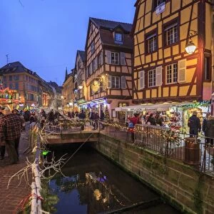 Tourists shopping at the Christmas Markets in the old medieval town of Colmar, Haut-Rhin department