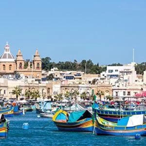 Traditional brightly painted fishing boats in the harbour at Marsaxlokk, Malta, Mediterranean