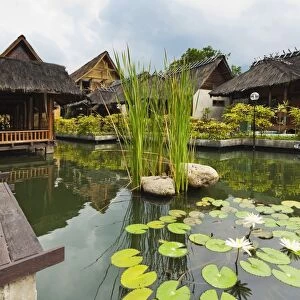 Traditional kampung style rooms over carp ponds at the Kampung Sumber Alam hot springs hotel, Garut, West Java, Java, Indonesia, Southeast Asia, Asia