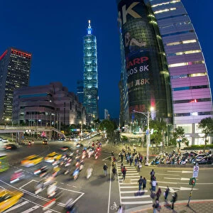 Traffic in front of Taipei 101 at a busy downtown intersection in the Xinyi district