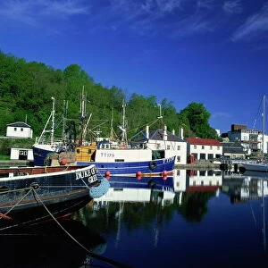 Tranquil scene of boats reflected in still water on the Crinan Canal
