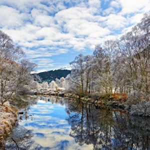 A tranquil view of Loch Doilet and surrounding trees on a calm and frosty winter