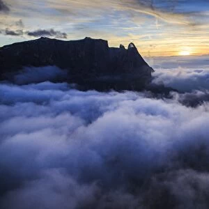 The unmistakable profile of the Sciliar Massif in the Dolomites emerging from the fog, South Tyrol, Italy, Europe
