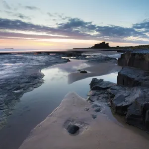 View towards Bamburgh Castle at sunrise from Bamburgh Beach, Bamburgh, Northumberland