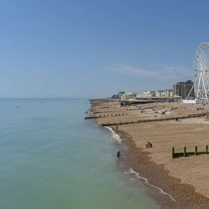 View of beach front houses and ferris wheel from the pier, Worthing, West Sussex, England