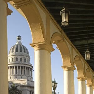 A view of the Capitolio seen through the arches of a colonial style arcade in central Havana