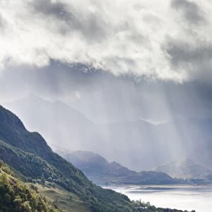 View from Carr Brae towards head of Loch Duich and Five Sisters of Kintail with rays of sunlight bursting through sky, Highlands, Scotland, United