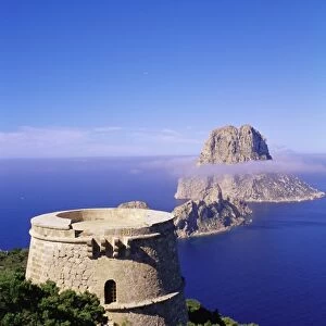 View of a defence tower and rocky islet of Es Vedra