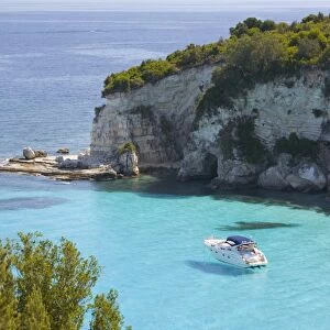 View from hillside over secluded Voutoumi Bay, solitary boat at anchor, Antipaxos, Paxi, Corfu, Ionian Islands, Greek Islands, Greece, Europe