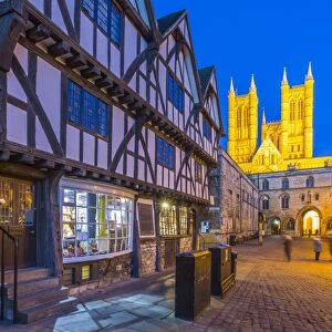 View of illuminated Lincoln Cathedral viewed from Exchequer Gate with timbered architecture