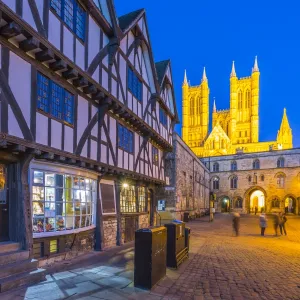 View of illuminated Lincoln Cathedral viewed from Exchequer Gate with timbered architecture