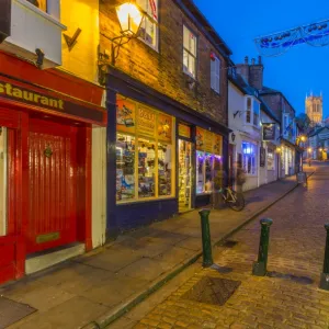 View of illuminated Lincoln Cathedral viewed from the cobbled Steep Hill at dusk