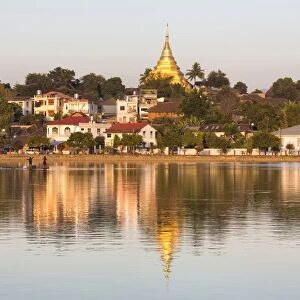 View of Kengtung (Kyaingtong) looking across Naung Tung Lake towards the town and gilded stupa of Wat Jong Kham bathed in evening light, Kengtung, Shan State, Myanmar (Burma), Asia