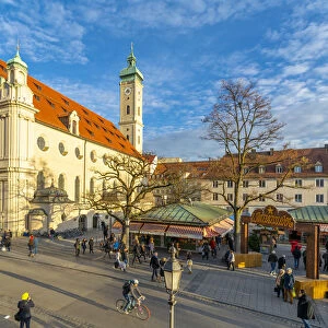 View of market and Heiliggeistkirche Church clock tower, Munich, Bavaria, Germany, Europe