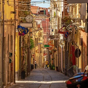 View of narrow street lined with rustic buildings in Sassari, Sassari, Sardinia, Italy, Mediterranean, Europe