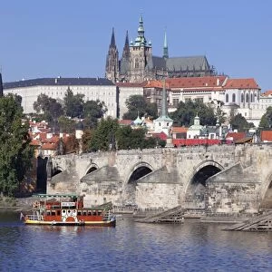 View over the River Vltava with excursion boat to Charles Bridge and the Castle District with St. Vitus Cathedral and Royal Palace, UNESCO World Heritage Site, Prague, Bohemia, Czech Republic, Europe