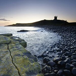 View across the Rumble Churn at dawn towards the ruins of Dunstanburgh Castle