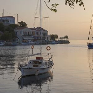 View across the tranquil harbour, sunrise, Gialos (Yialos), Symi (Simi), Rhodes, Dodecanese Islands